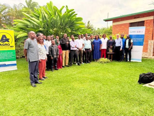 An agricultural extension officer advising a group of farmers in the field
